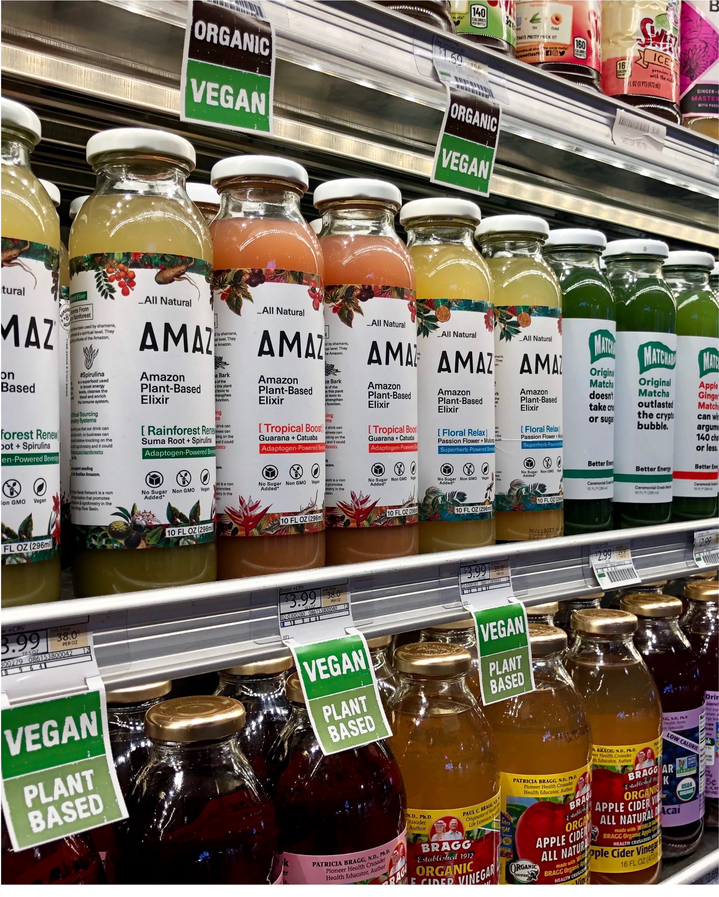 AMAZ Amazon Plant-Based Elixir bottles in Whole Foods refrigerator with organic and vegan tags